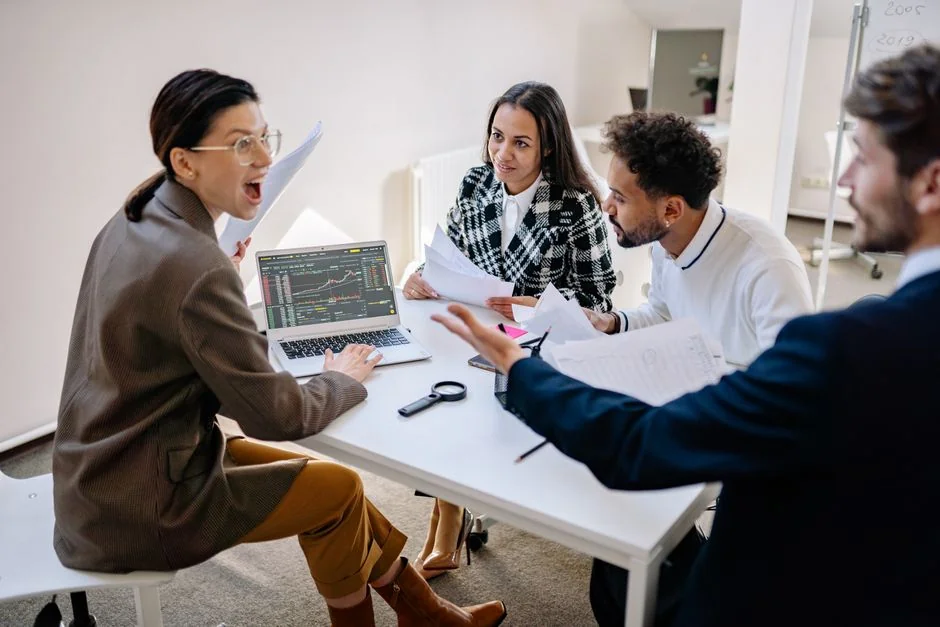 A diverse team collaborating on digital marketing strategies at a desk, using laptops and tablets.